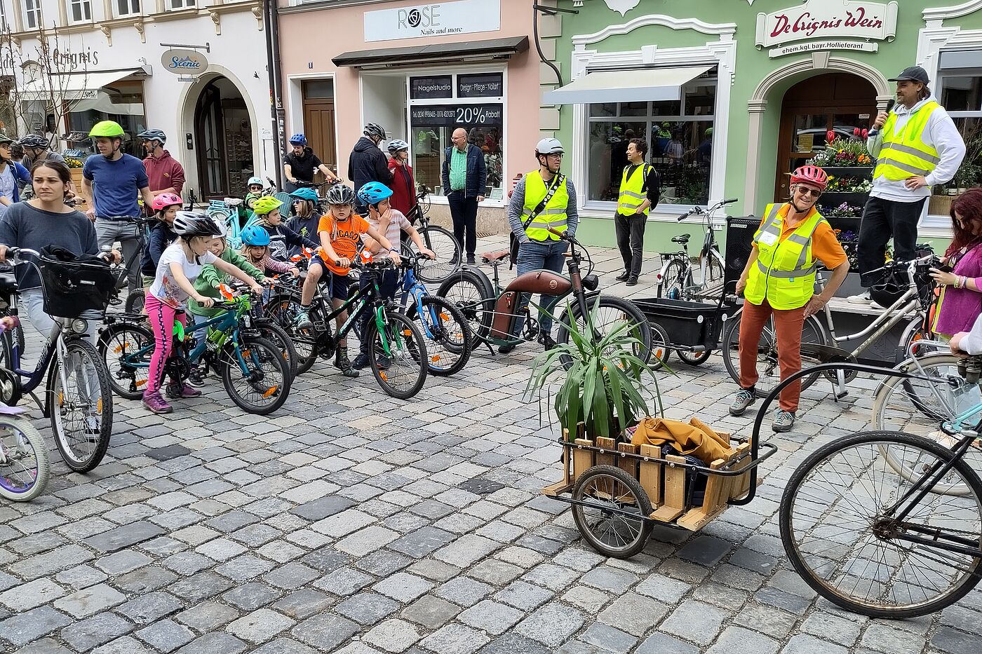 Begrüßung Mann mit Micro und Kinder auf Fahrrädern