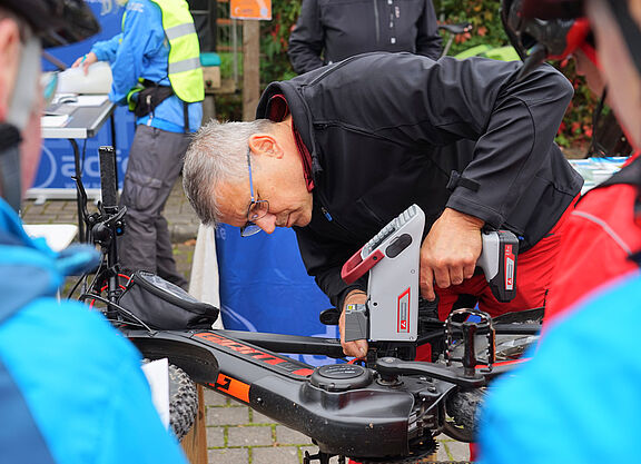 Fahrradcodieren Mann mit Codiergerät codiert ein Fahrrad